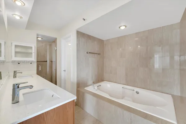 a bathroom with a tub a sink and mirror