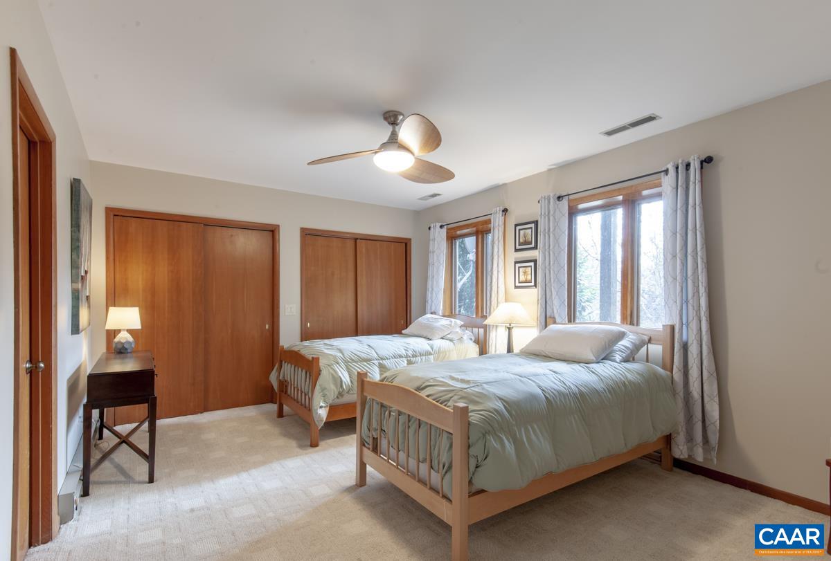 397 Rodes Valley Drive Nellysford, VA 22958 - Photo 29 of 46 a bedroom with a bed and a chandelier next to a window