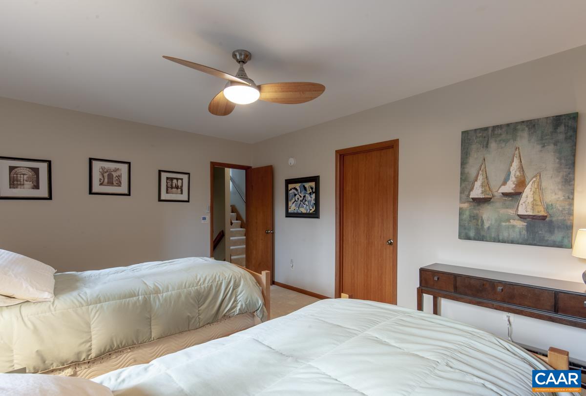 397 Rodes Valley Drive Nellysford, VA 22958 - Photo 30 of 46 a bedroom with a large bed and a chandelier