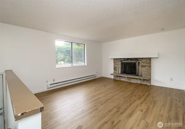 an empty room with wooden floor and fireplace