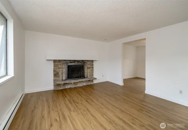an empty room with wooden floor and a fireplace