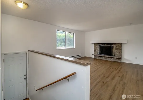 an empty room with wooden floor cabinet and windows