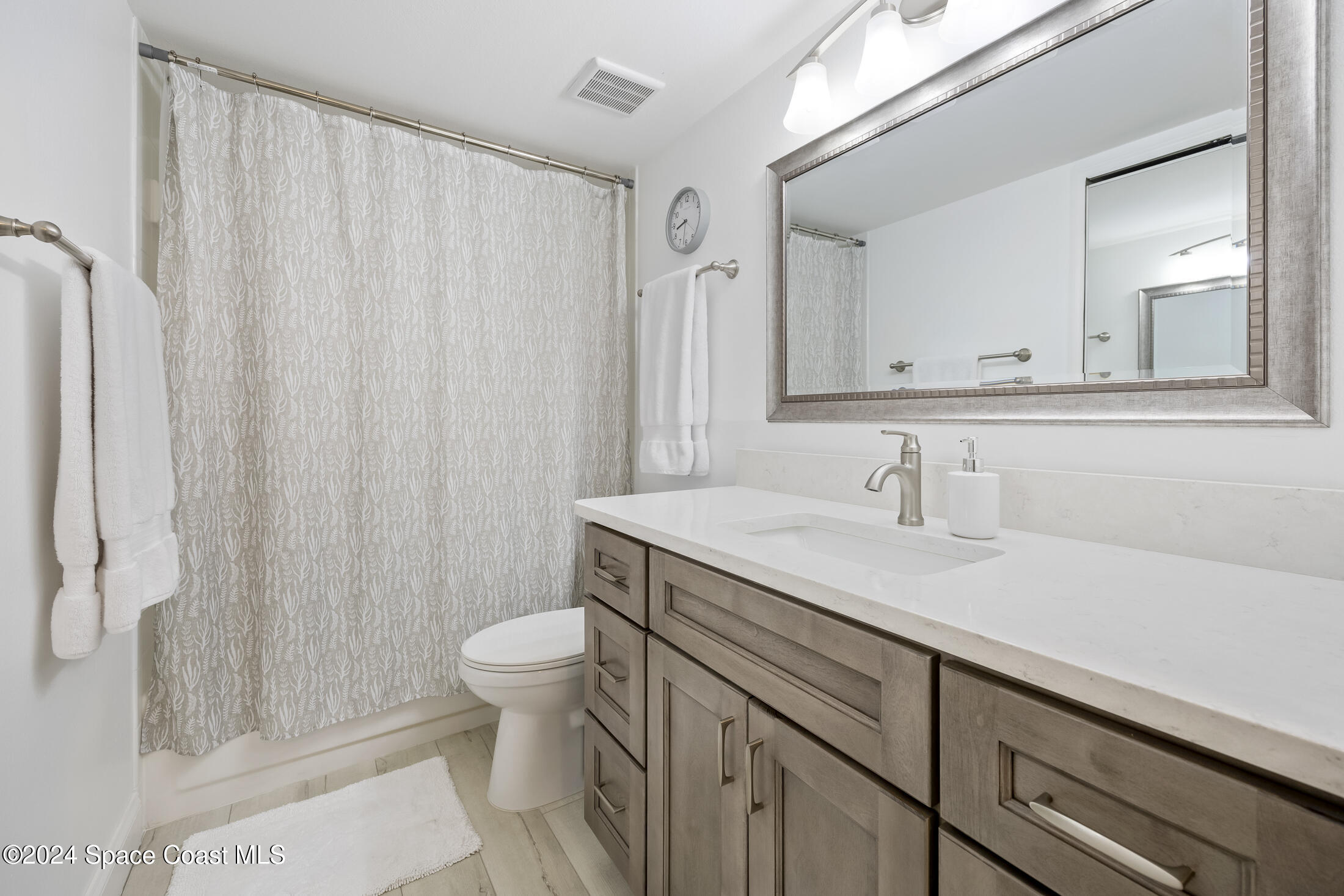 7030 N Highway, Unit DD205 Cocoa, FL 32927 - Photo 18 of 34 a bathroom with a sink a toilet and a mirror