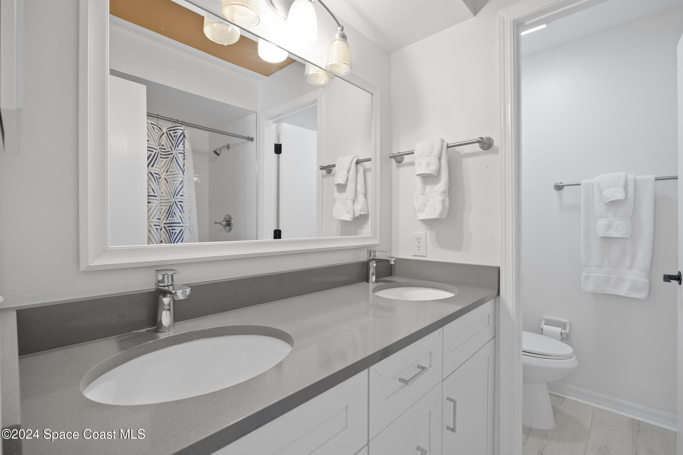 7030 N Highway, Unit DD205 Cocoa, FL 32927 - Photo 25 of 34 a bathroom with a granite countertop sink a toilet and a mirror