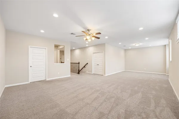 a view of an empty room with a ceiling fan
