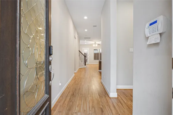a view of a hallway with wooden floor and staircase