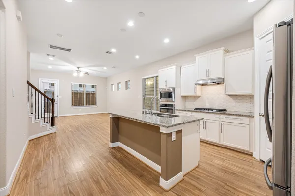 a kitchen with stainless steel appliances granite countertop a sink stove and refrigerator