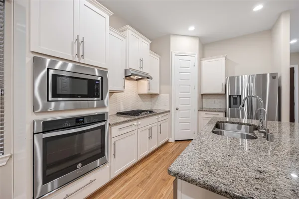 a kitchen with stainless steel appliances granite countertop a stove microwave and sink