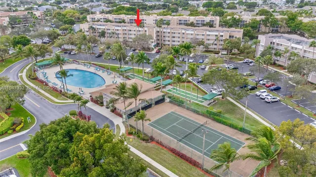 an aerial view of residential houses with outdoor space and trees