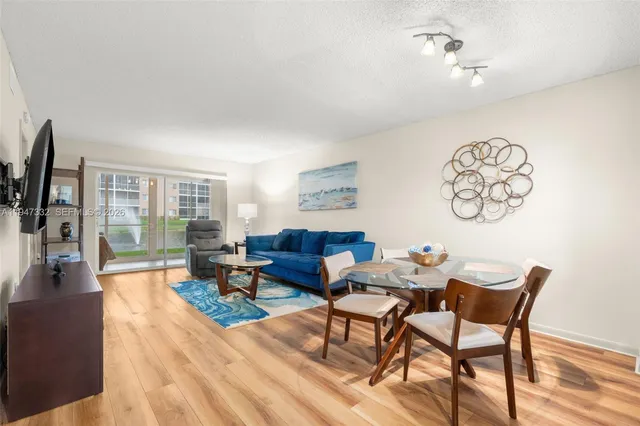 a living room with furniture a flat screen tv and a dining table