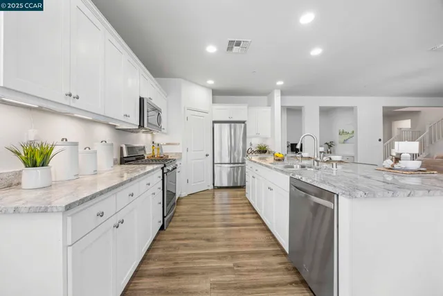 a kitchen with a faucet a sink and a wooden floor