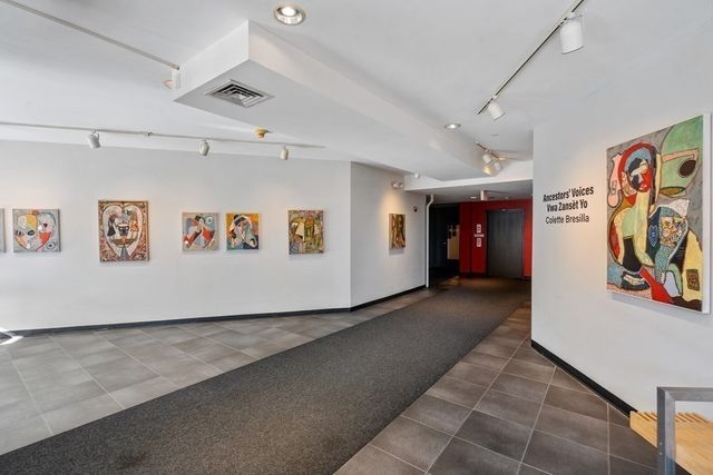 a view of a hallway with paintings on the wall