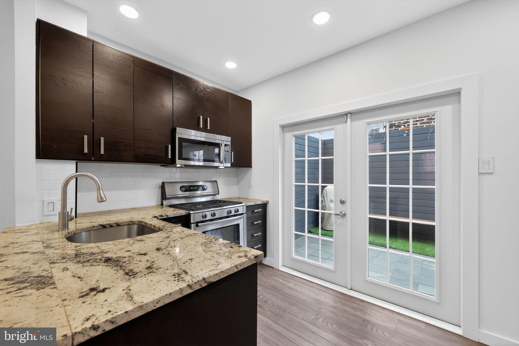 608 Kater Street Philadelphia, PA 19147 - Photo 19 of 30 a kitchen with stainless steel appliances granite countertop a sink stove and refrigerator