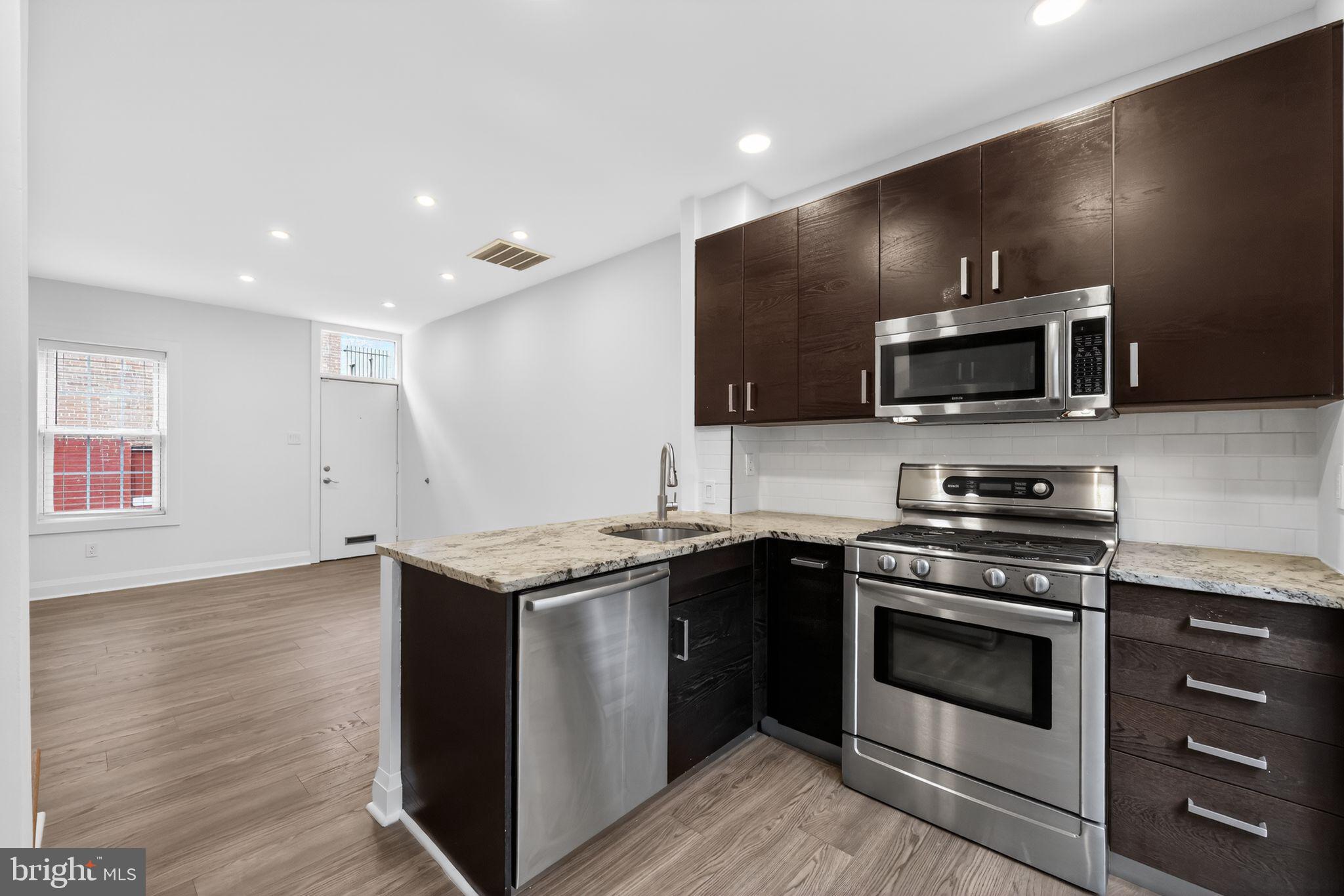 608 Kater Street Philadelphia, PA 19147 - Photo 21 of 30 a kitchen with stainless steel appliances a stove microwave and sink
