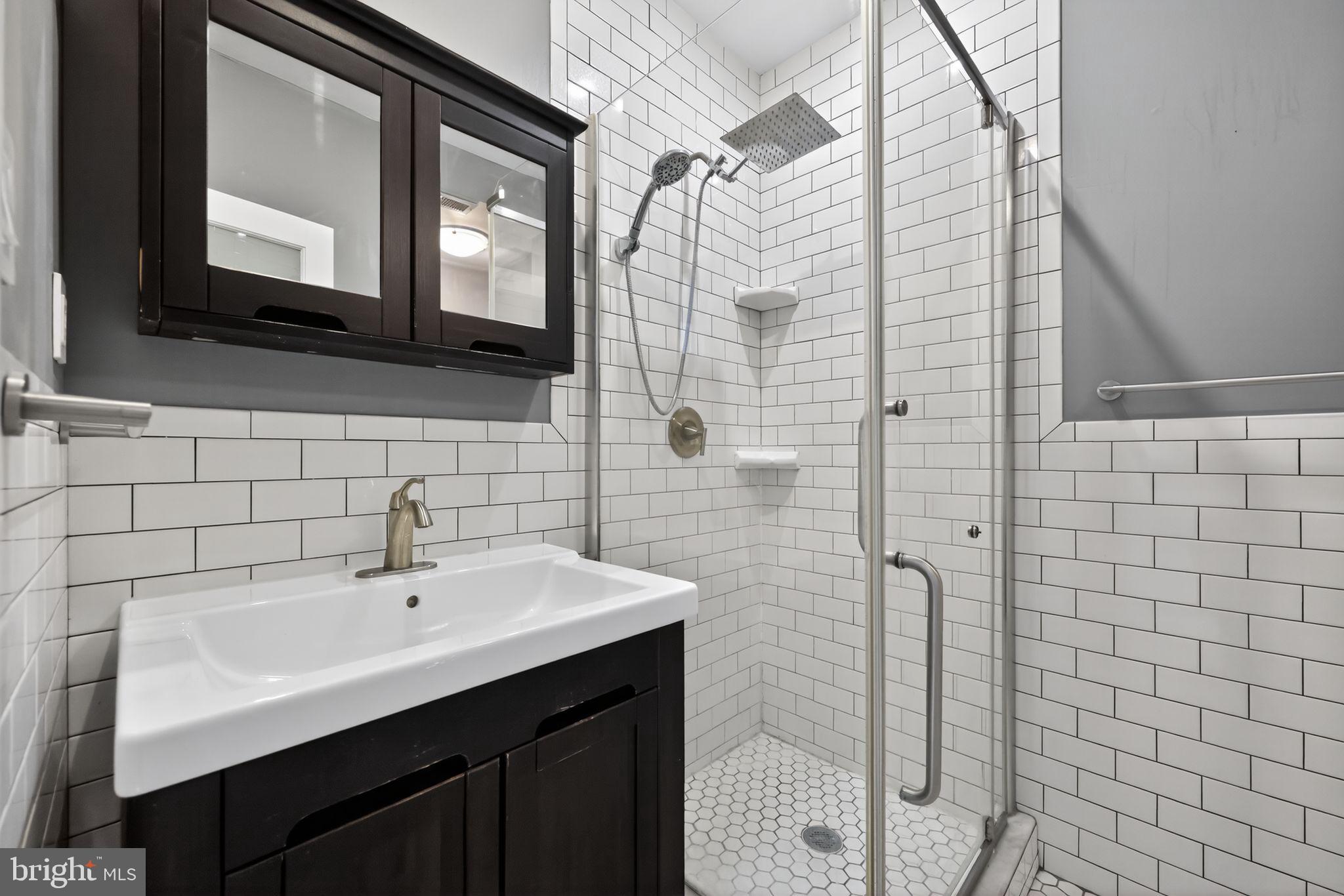 608 Kater Street Philadelphia, PA 19147 - Photo 22 of 30 a bathroom with a sink a mirror and shower