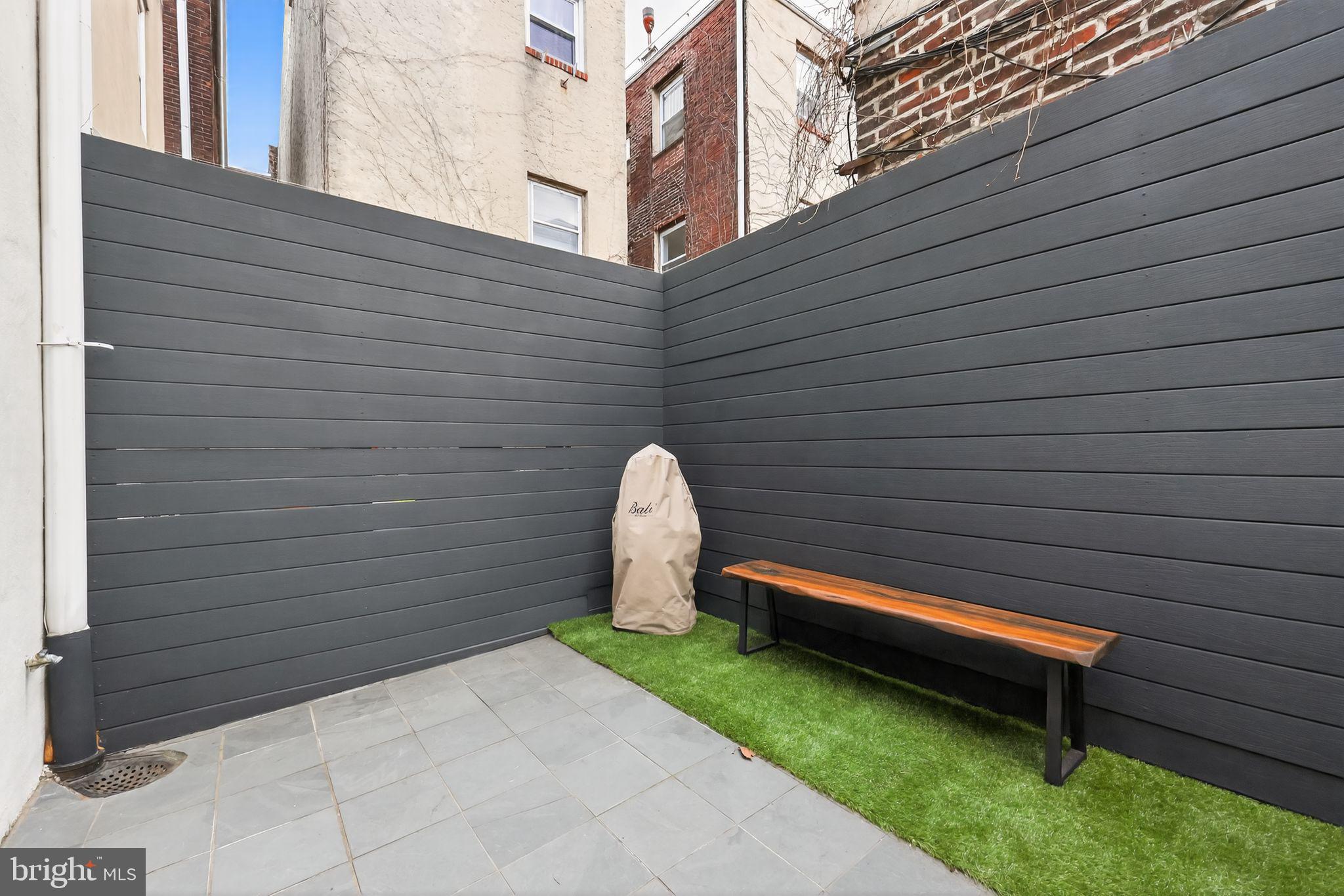 608 Kater Street Philadelphia, PA 19147 - Photo 27 of 30 a backyard of a house with a table and chairs