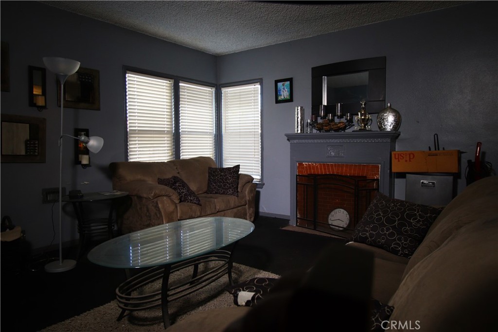 4522 East Rosecrans Avenue Compton, CA 90221 - Photo 21 of 75 a living room with furniture a flat screen tv and a fireplace