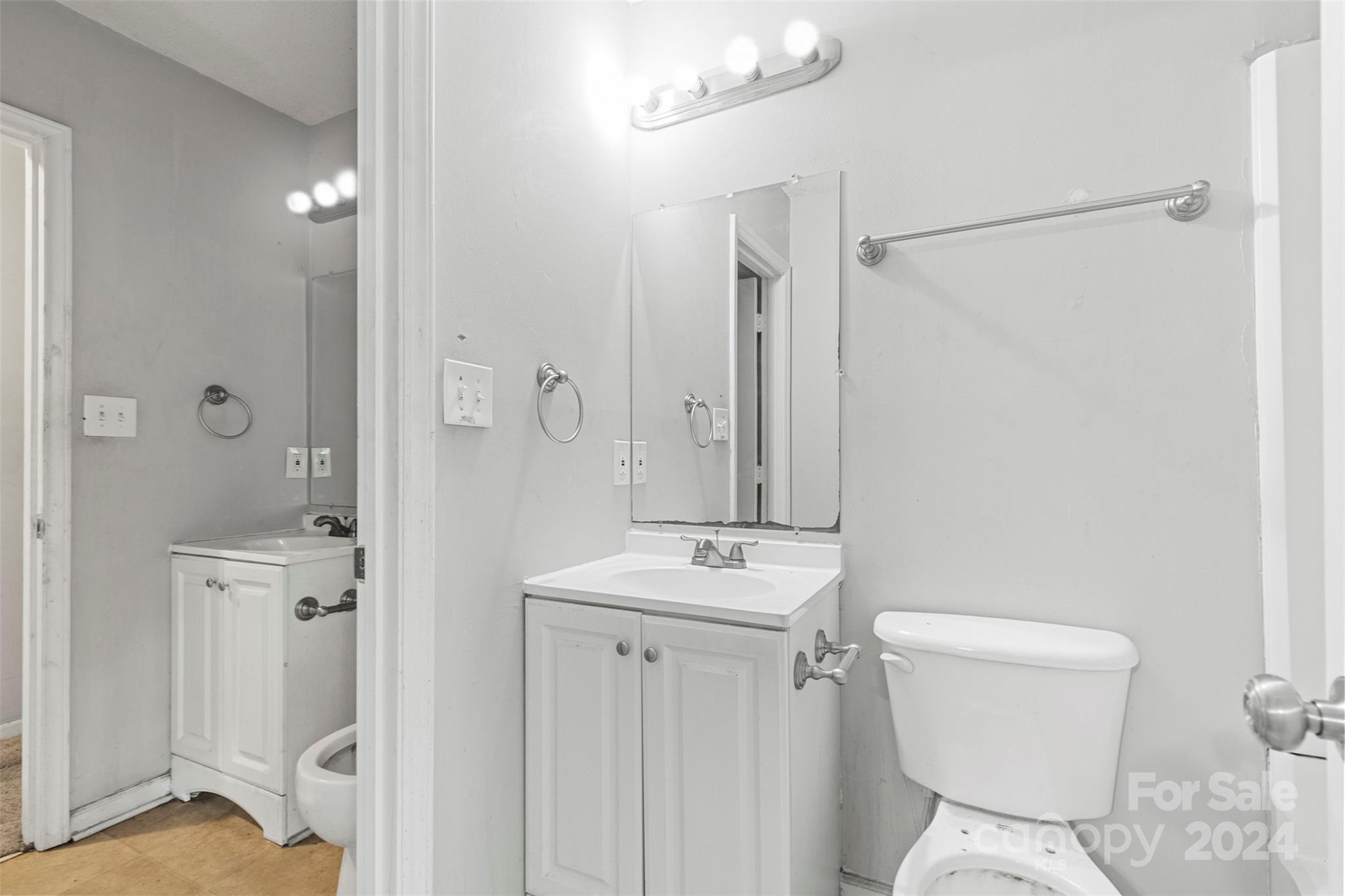 6803 North Ridge Court Charlotte, NC 28215 - Photo 19 of 30 a bathroom with a sink a toilet a mirror and shower