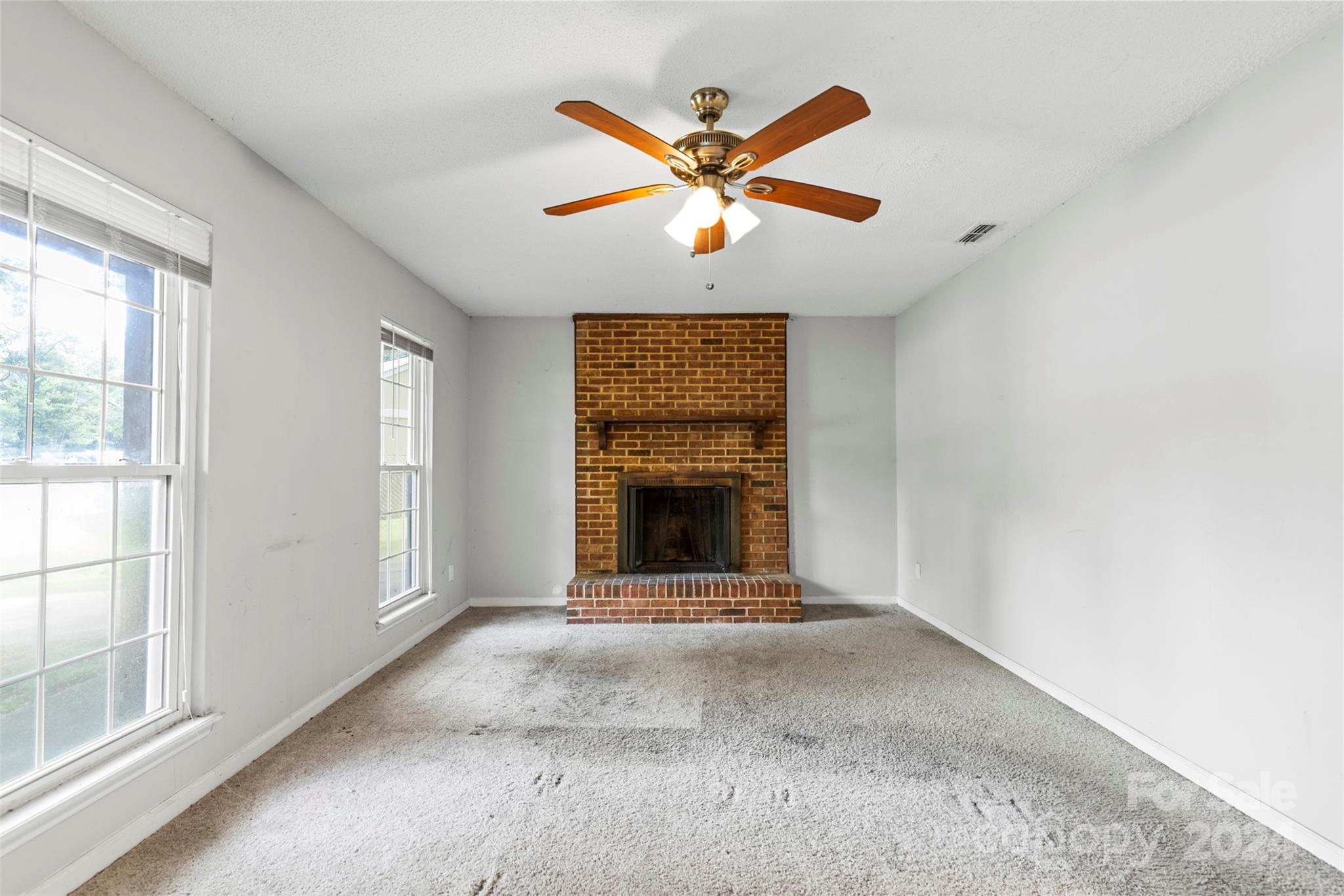 6803 North Ridge Court Charlotte, NC 28215 - Photo 2 of 30 a view of an empty room with chandelier fan and windows