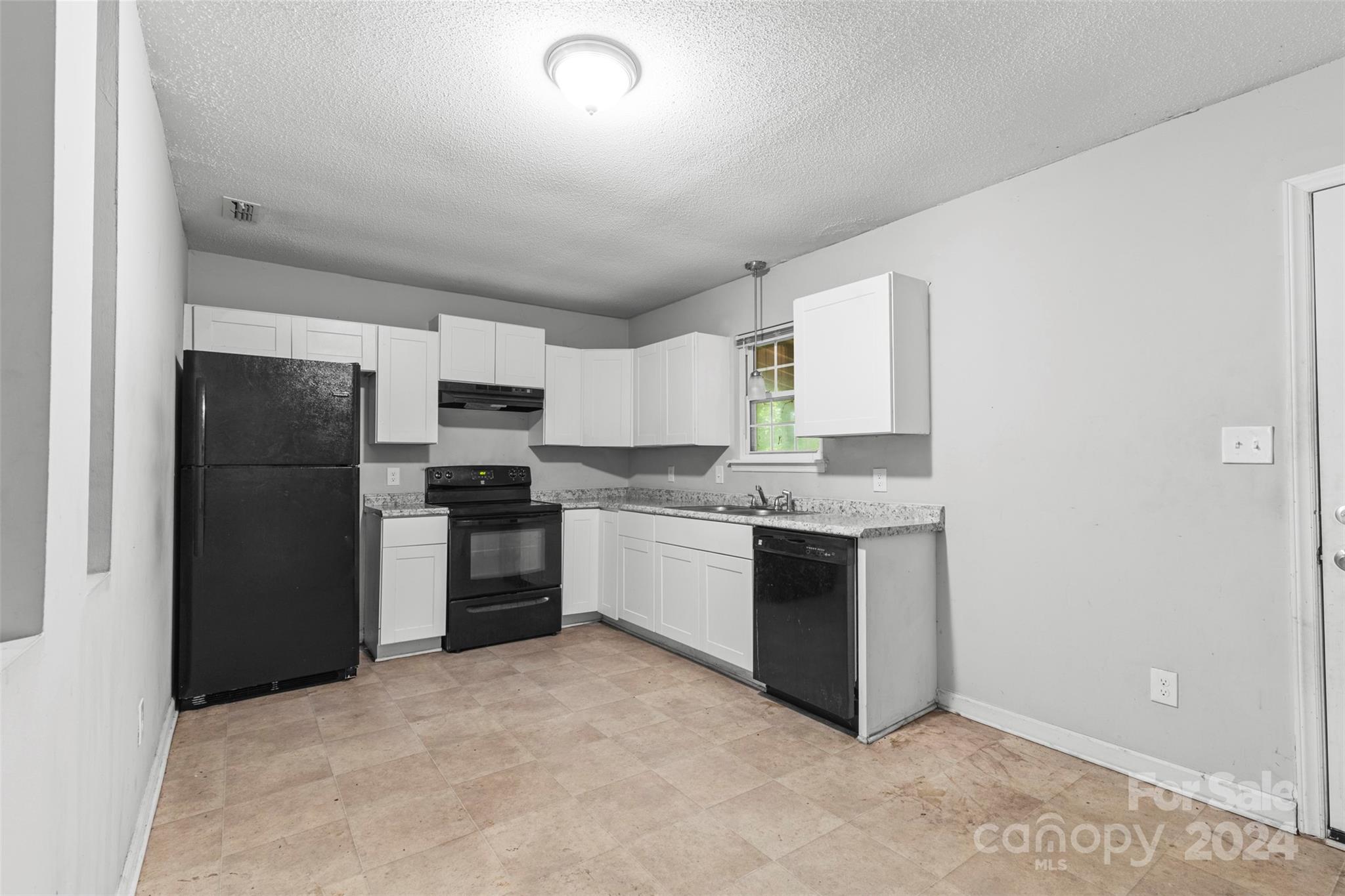6803 North Ridge Court Charlotte, NC 28215 - Photo 9 of 30 a large kitchen with a refrigerator and a stove top oven