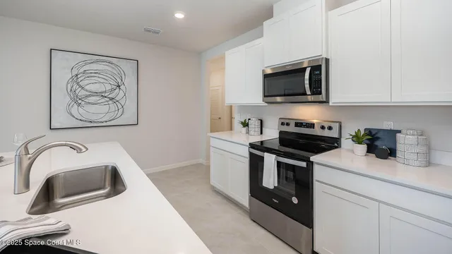 a kitchen with stainless steel appliances granite countertop a sink a stove a microwave and cabinets