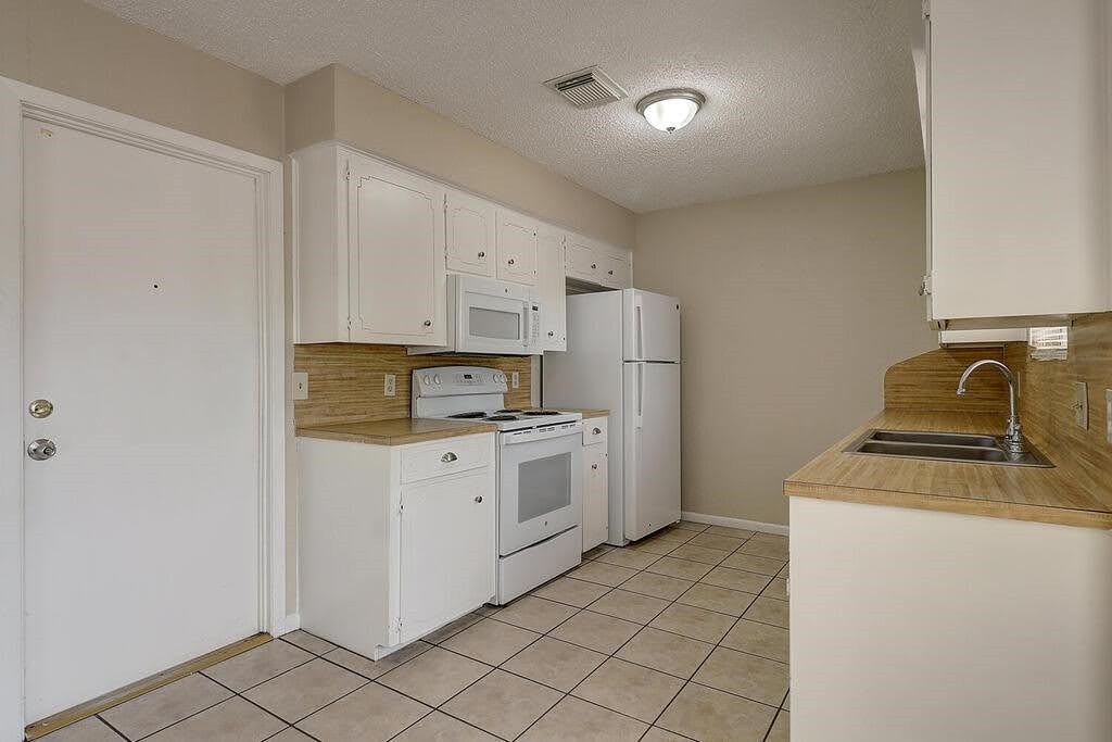 5225 Bonham Street Corpus Christi, TX 78415 - Photo 13 of 40 a kitchen with a stove top oven and cabinets