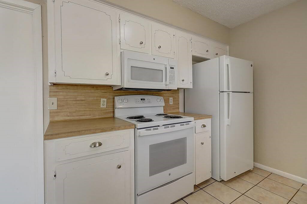 5225 Bonham Street Corpus Christi, TX 78415 - Photo 15 of 40 a kitchen with white cabinets and white appliances