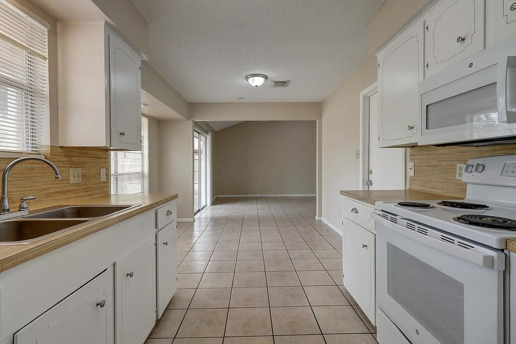 5225 Bonham Street Corpus Christi, TX 78415 - Photo 18 of 40 a kitchen with a stove sink and cabinets
