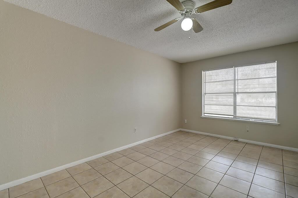 5225 Bonham Street Corpus Christi, TX 78415 - Photo 19 of 40 an empty room with chandelier fan and windows