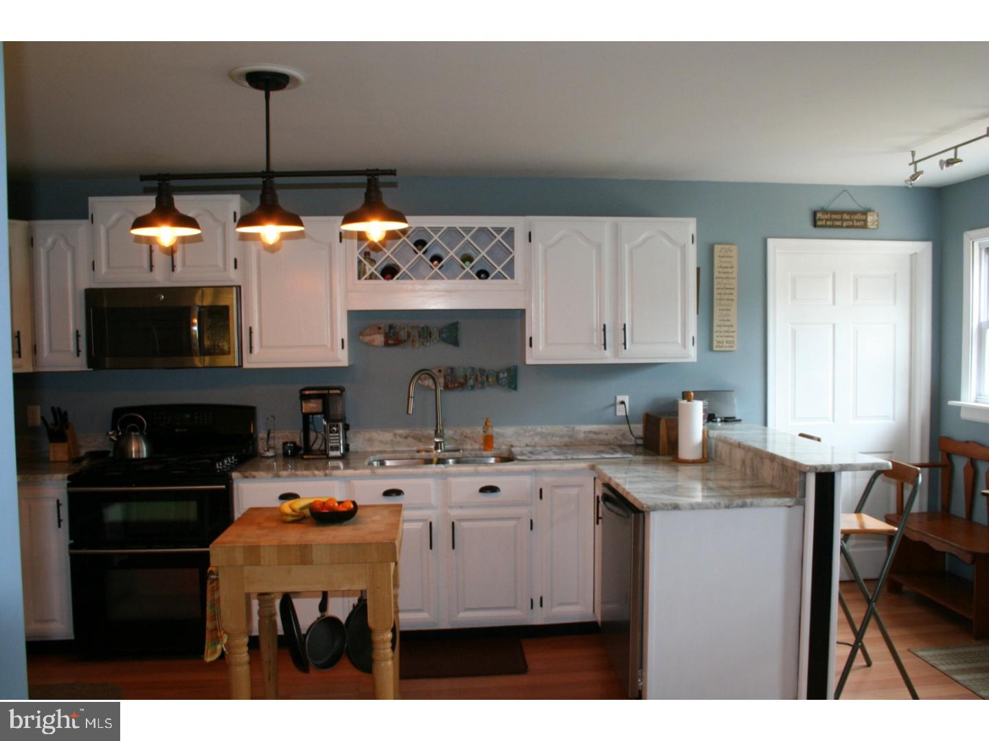 468 Alvine Road Elmer, NJ 08318 - Photo 17 of 25 a kitchen with a sink a microwave a dining table and chairs