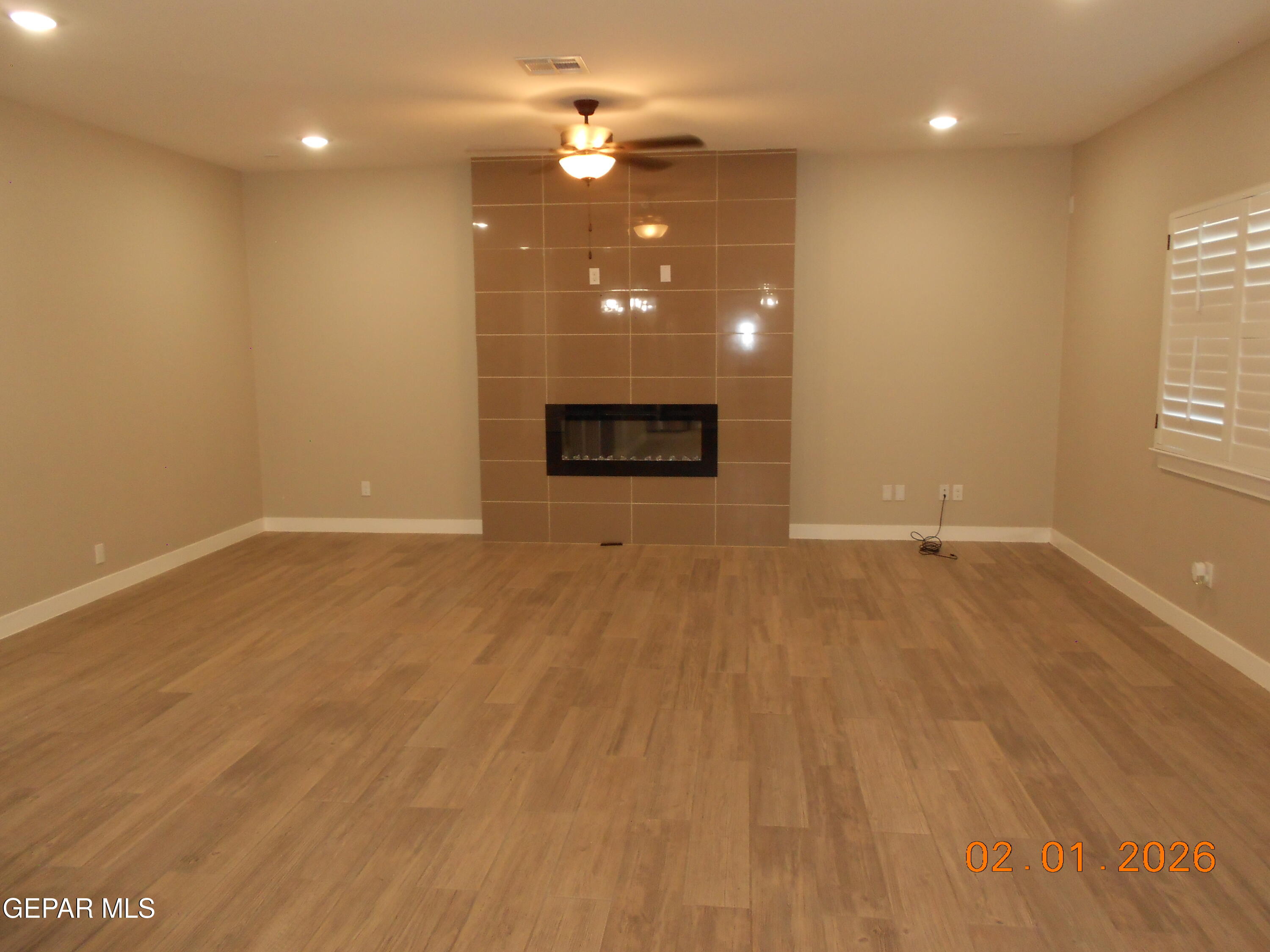 10013 Hueco Jct Road Socorro, TX 79927 - Photo 9 of 27 an empty room with wooden floor and windows