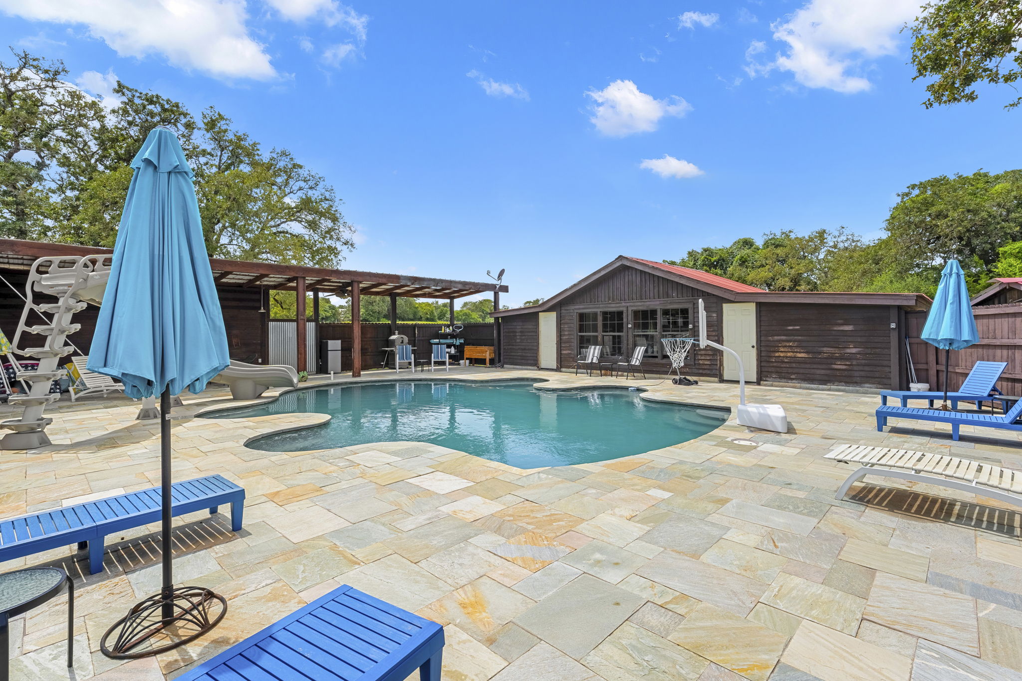 206 22 Hills Road Gause, TX 77857 - Photo 11 of 28 An inviting swimming pool is surrounded by extensive stone tile decking and mature trees.