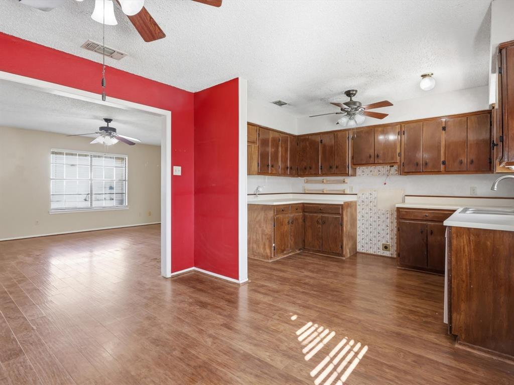 701 College Street Celeste, TX 75423 - Photo 9 of 29 a kitchen with stainless steel appliances granite countertop a refrigerator a sink dishwasher a stove with wooden floor