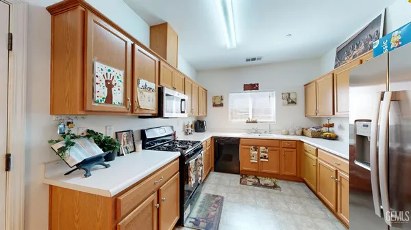 a kitchen with stainless steel appliances granite countertop a sink stove refrigerator and cabinets
