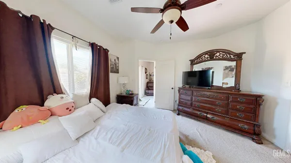 a bedroom with a bed a window and dresser