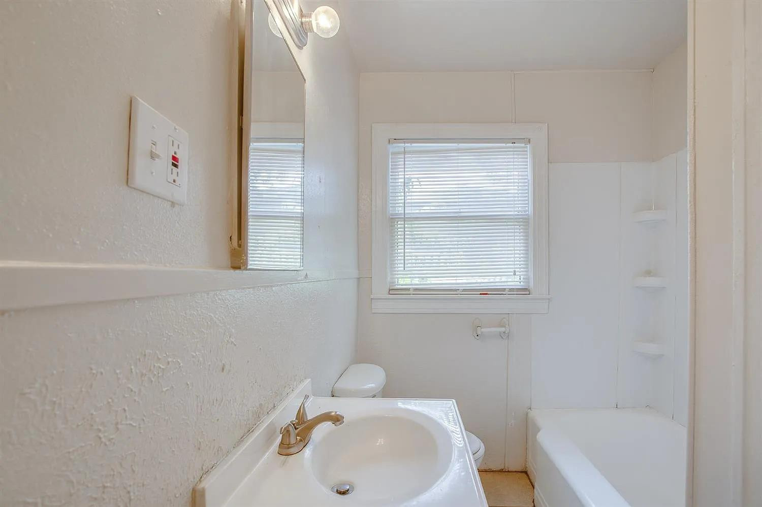 2708 33rd Street Lubbock, TX 79410 - Photo 11 of 12 a bathroom with a sink and a bathtub
