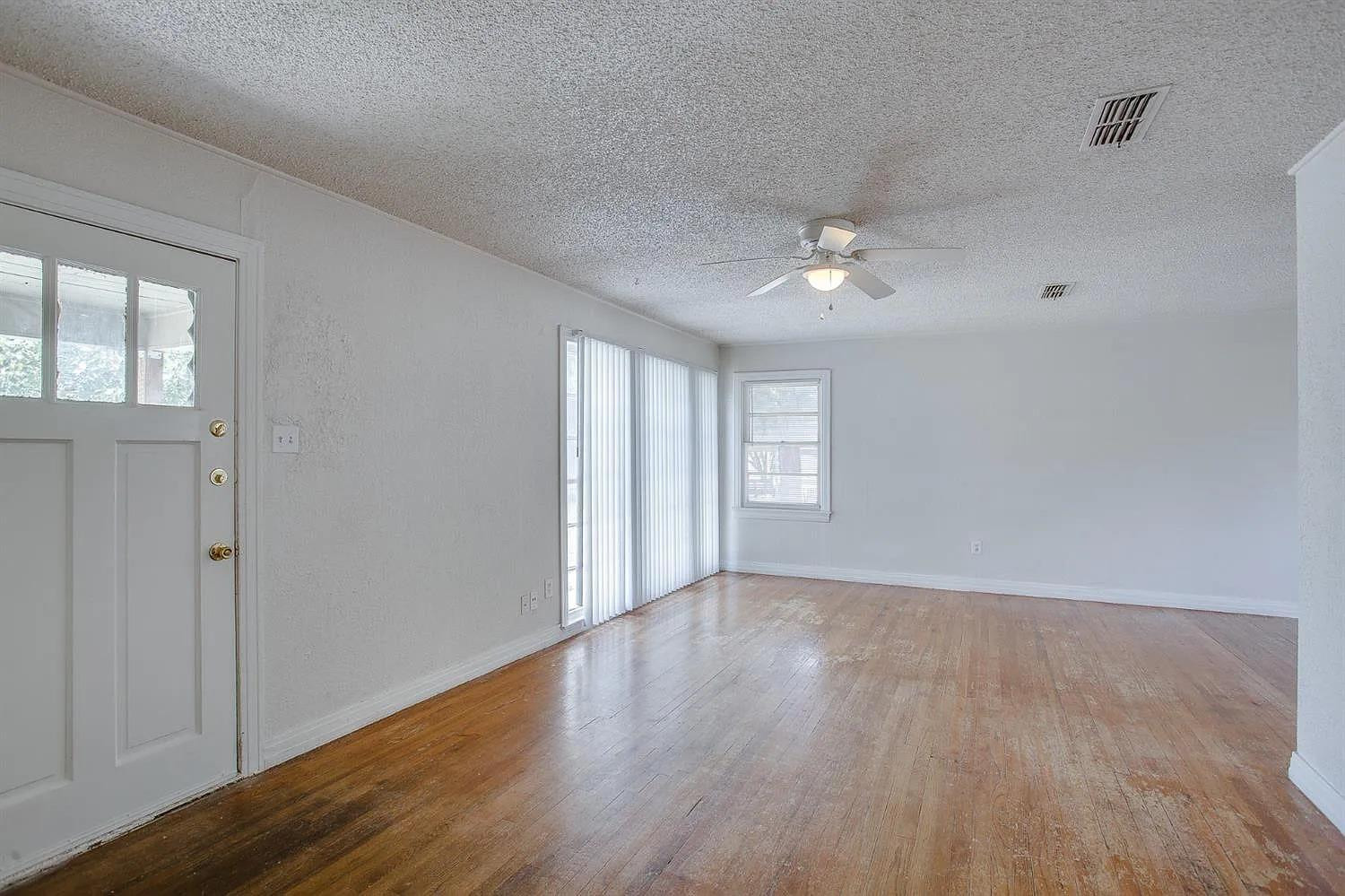 2708 33rd Street Lubbock, TX 79410 - Photo 2 of 12 wooden floor in an empty room with a window