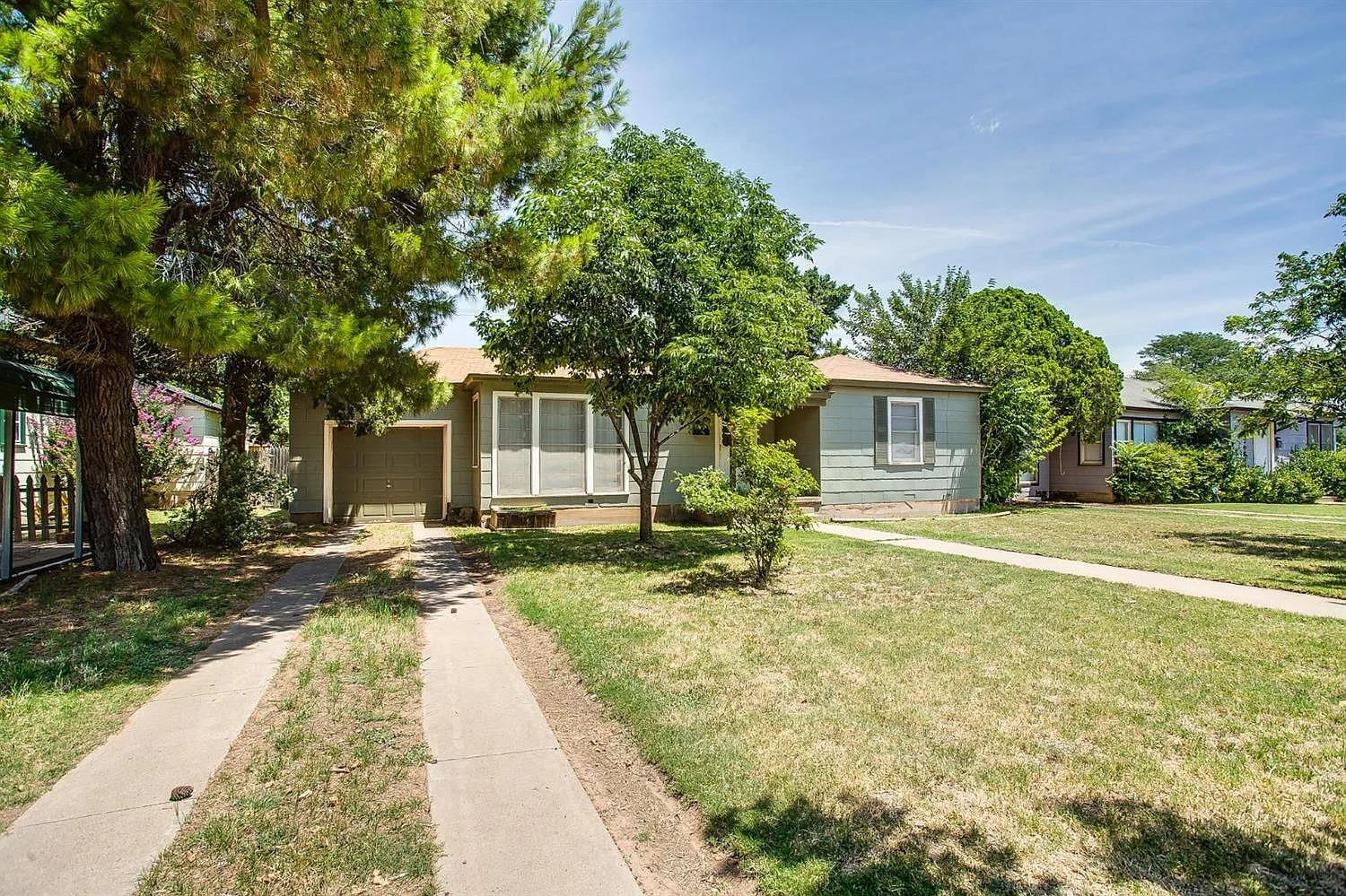 2708 33rd Street Lubbock, TX 79410 - Photo 3 of 12 a front view of a house with a garden and trees