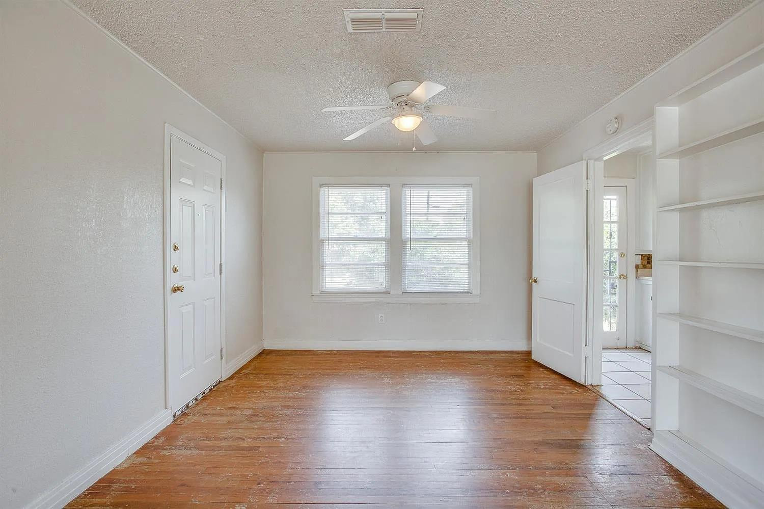2708 33rd Street Lubbock, TX 79410 - Photo 5 of 12 an empty room with wooden floor and windows