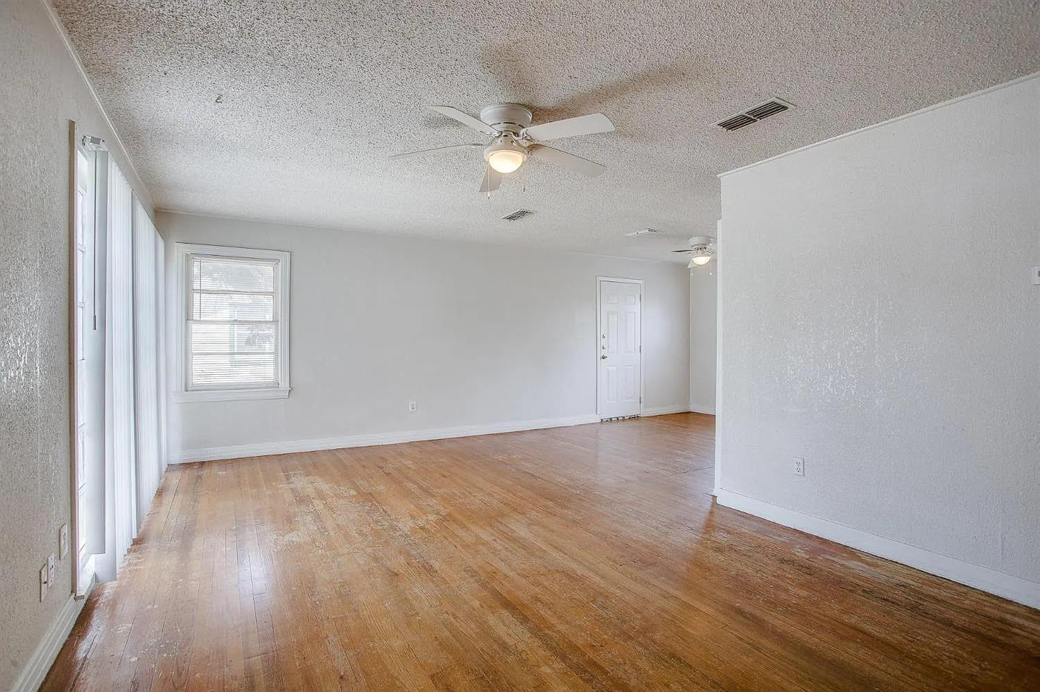 2708 33rd Street Lubbock, TX 79410 - Photo 10 of 12 an empty room with wooden floor fan and windows