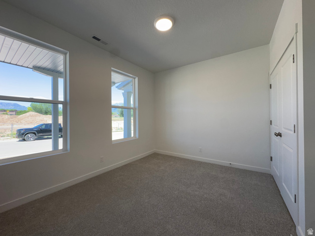 1472 North 1875 West, Unit 151 Layton, UT 84041 - Photo 3 of 20 Carpeted room featuring two large windows, white walls, and a white paneled door