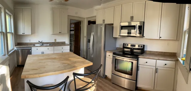 a kitchen with stainless steel appliances a stove a sink refrigerator and cabinets