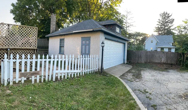 a white house that has tree in front of it