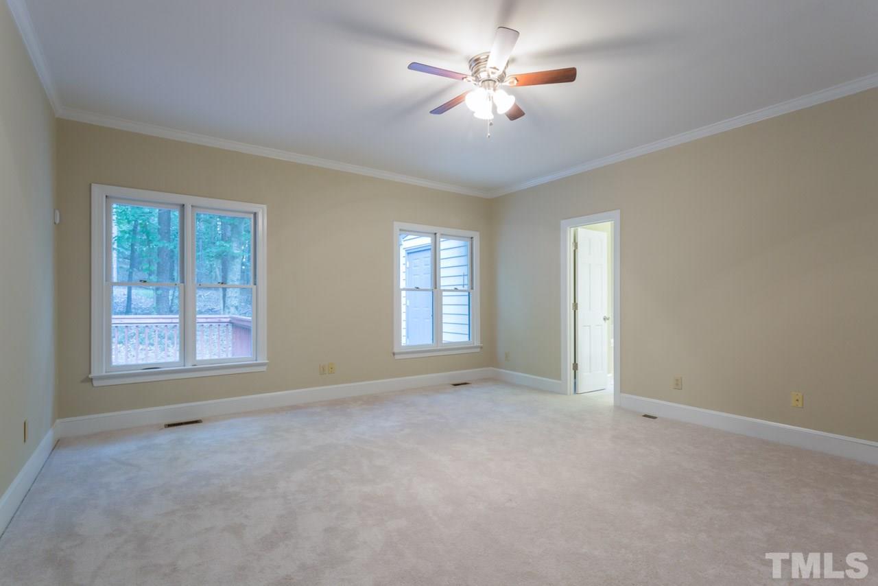 2909 Patrie Place Raleigh, NC 27613 - Photo 12 of 25 an empty room with chandelier fan and windows