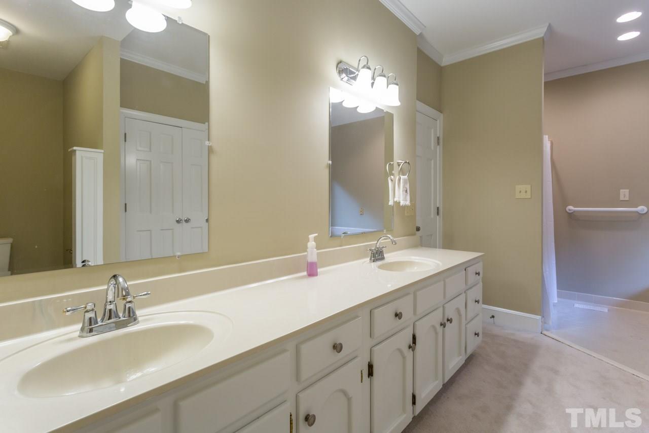 2909 Patrie Place Raleigh, NC 27613 - Photo 13 of 25 a bathroom with double vanity sinks and a mirror