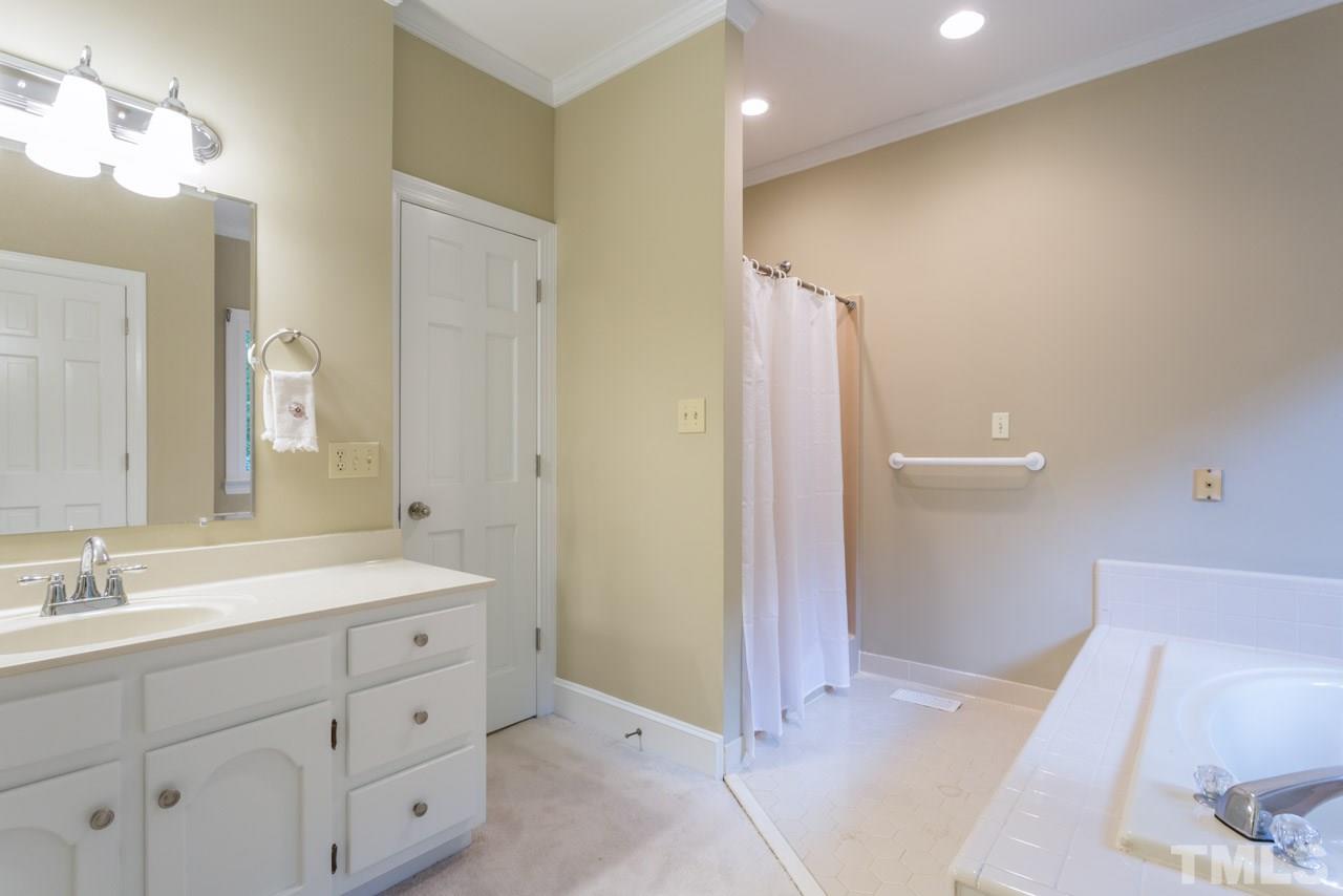 2909 Patrie Place Raleigh, NC 27613 - Photo 15 of 25 a spacious bathroom with a double vanity sink a mirror and a shower