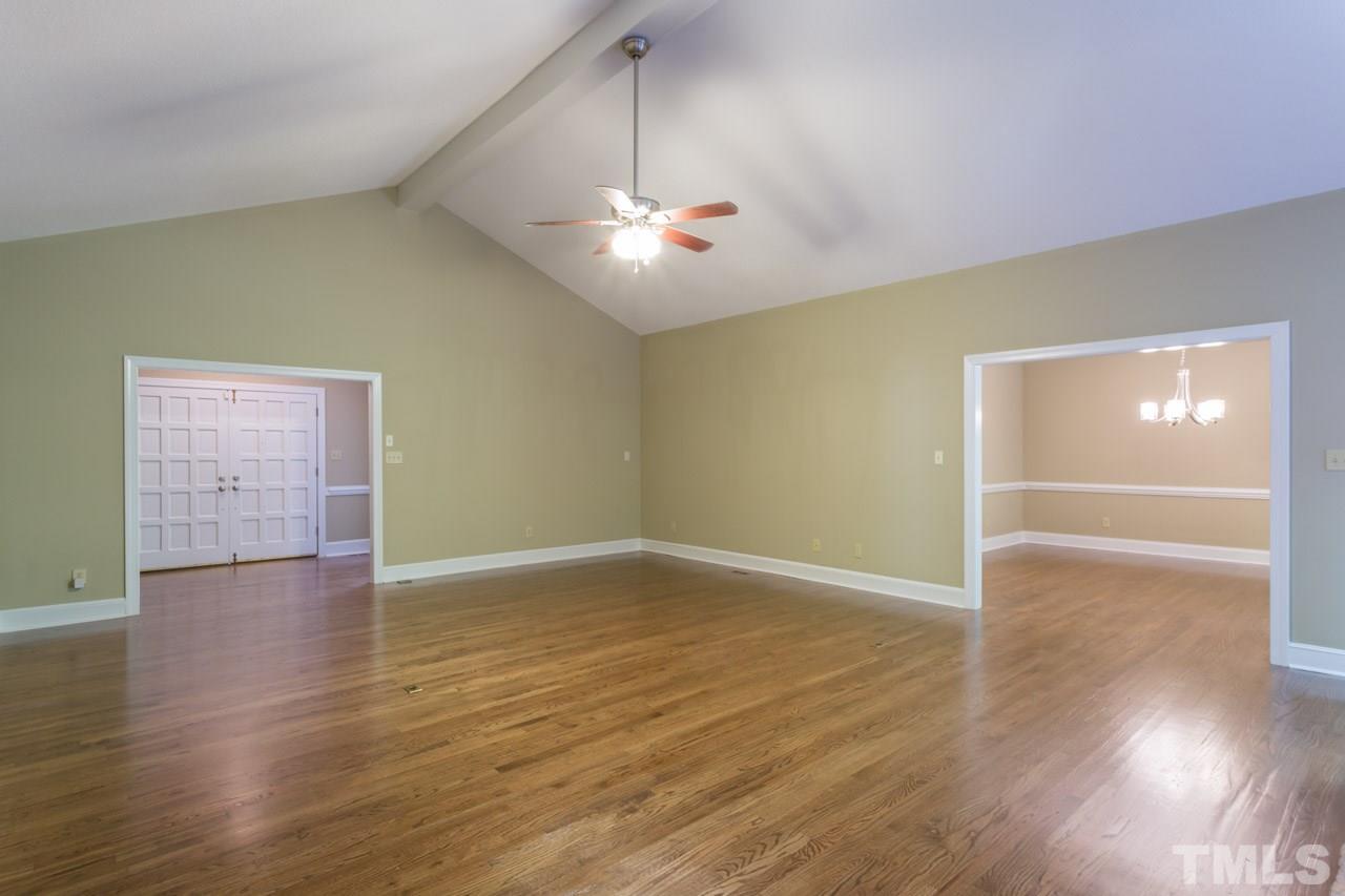 2909 Patrie Place Raleigh, NC 27613 - Photo 5 of 25 a view of an empty room with wooden floor and a ceiling fan