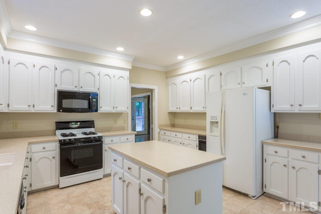 2909 Patrie Place Raleigh, NC 27613 - Photo 8 of 25 a kitchen with white cabinets and stainless steel appliances