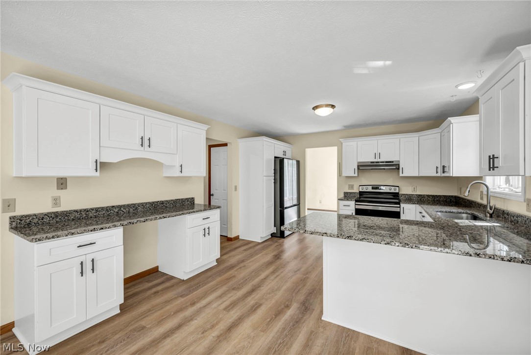 9842 Johnnycake Ridge Road Mentor, OH 44060 - Photo 10 of 40 Kitchen featuring white shaker cabinetry, granite countertops, wood-finish flooring, a stainless steel sink with a gooseneck faucet, and a range with an overhead microwave