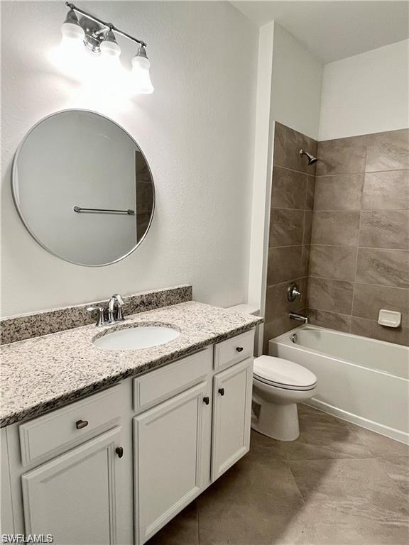 2057 Tamarron Lane Naples, FL 34120 - Photo 12 of 27 a bathroom with a granite countertop toilet a sink and a mirror